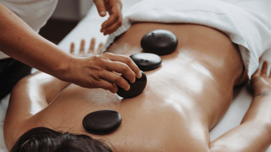 Hot stone massage for back pain uses soothing heat to help relax surrounding muscles and encourage healthy circulation